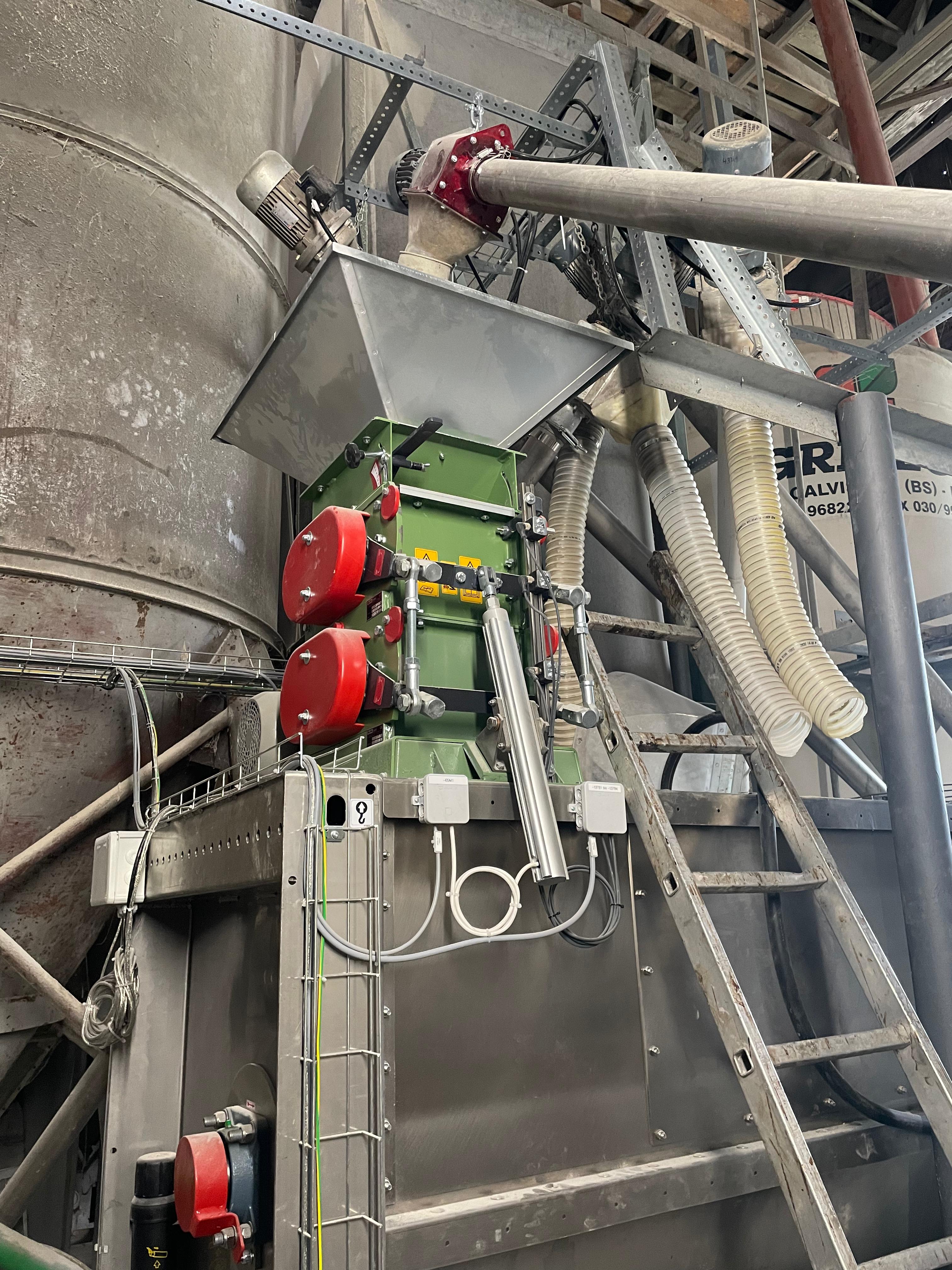 Mühle auf Edelstahl-Trichter mit Schneckenförderer in einer Produktionshalle