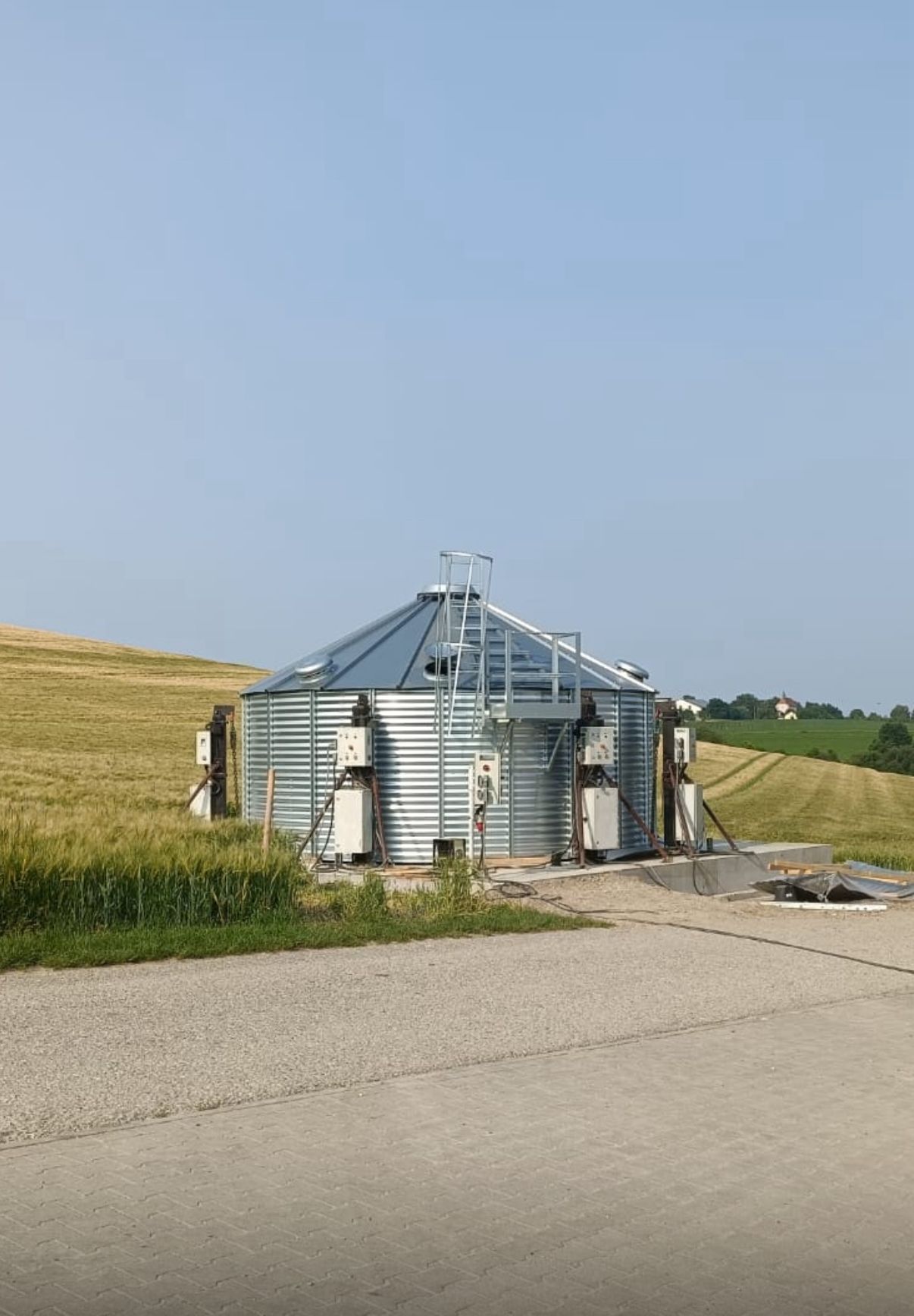 Siloaufbau mit Hydraulikheber auf einer Baustelle mit Hügellandschaft
